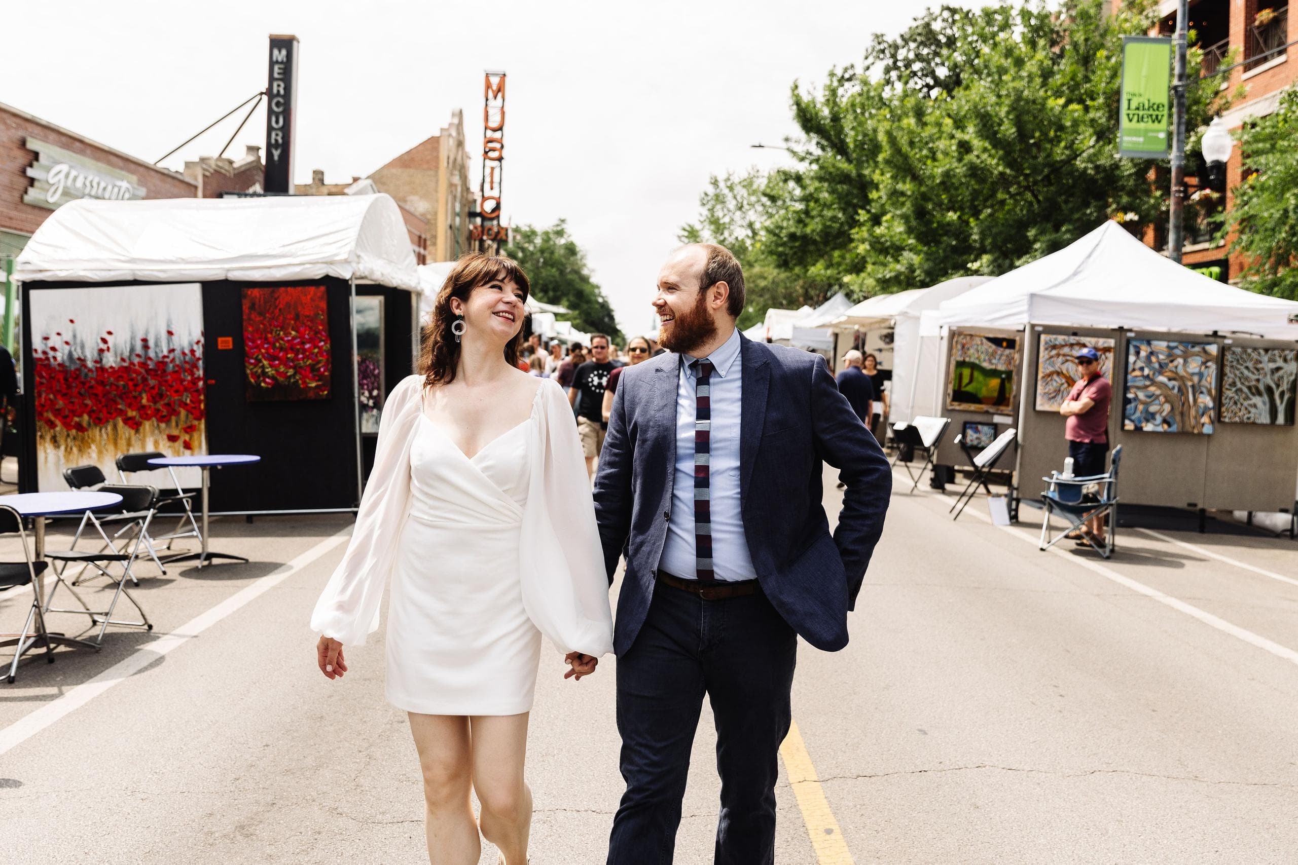 Engagement photo of the couple walking through an outdoor market